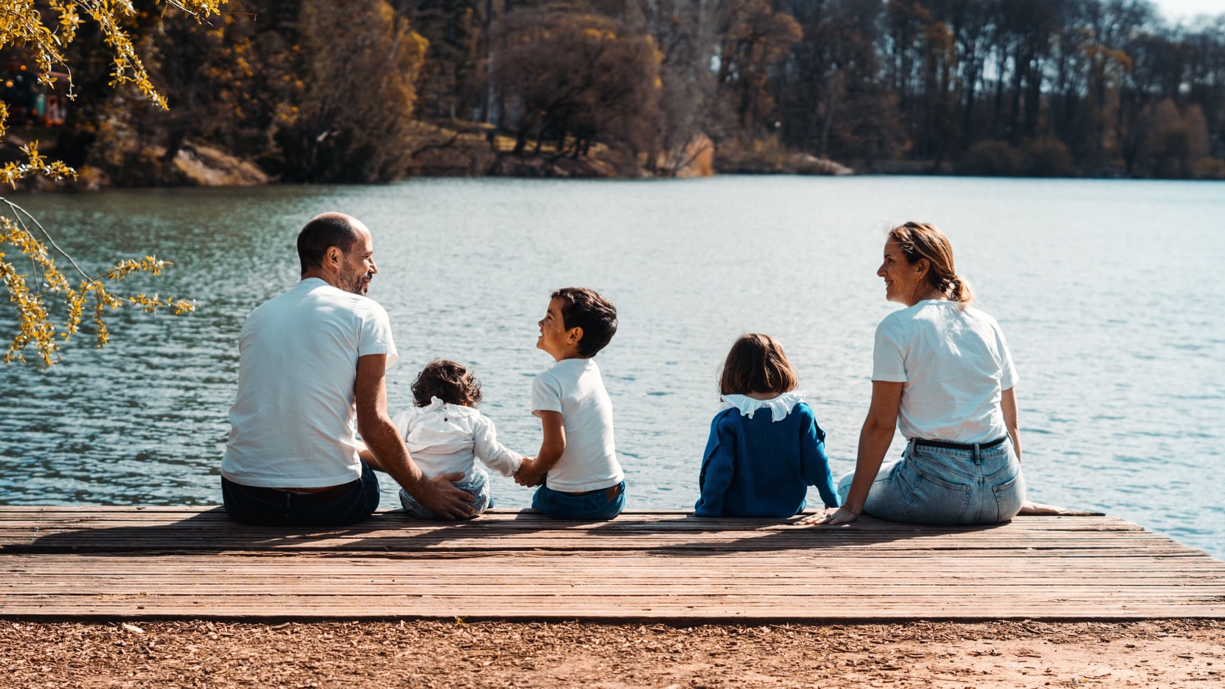 A family sitting together beside a lake